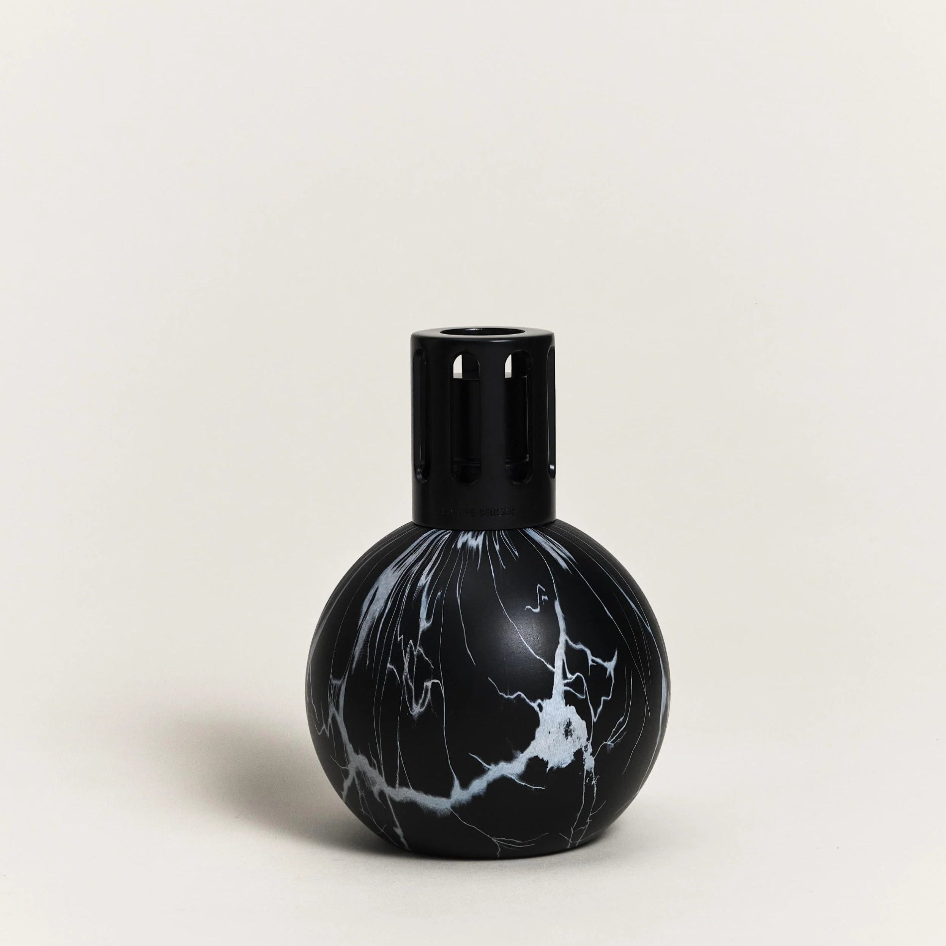 A black marble pattern fragrance lamp from Maison Berger Paris, with a round shape and a visible wick at the top.