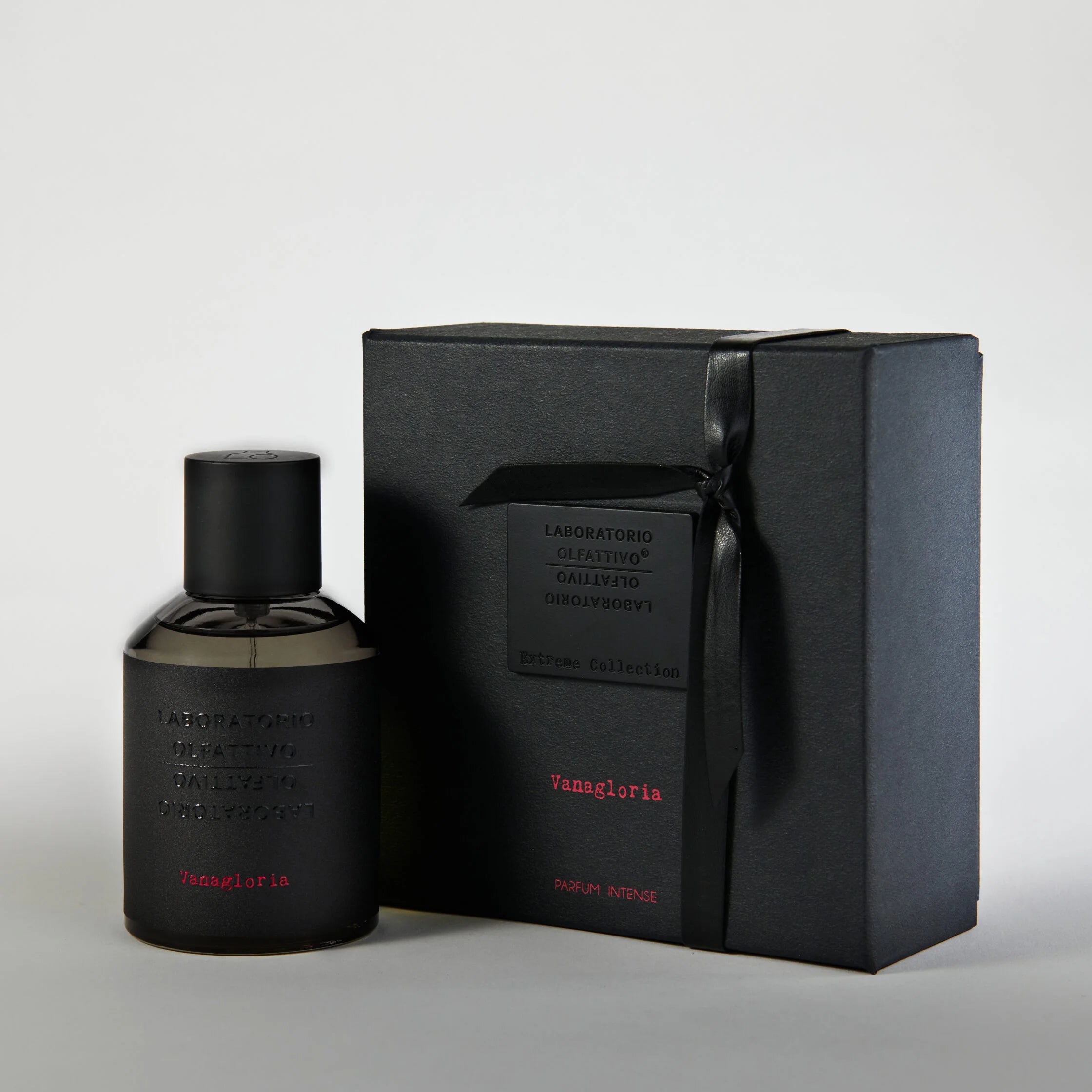 Black perfume bottle and packaging on a light gray background