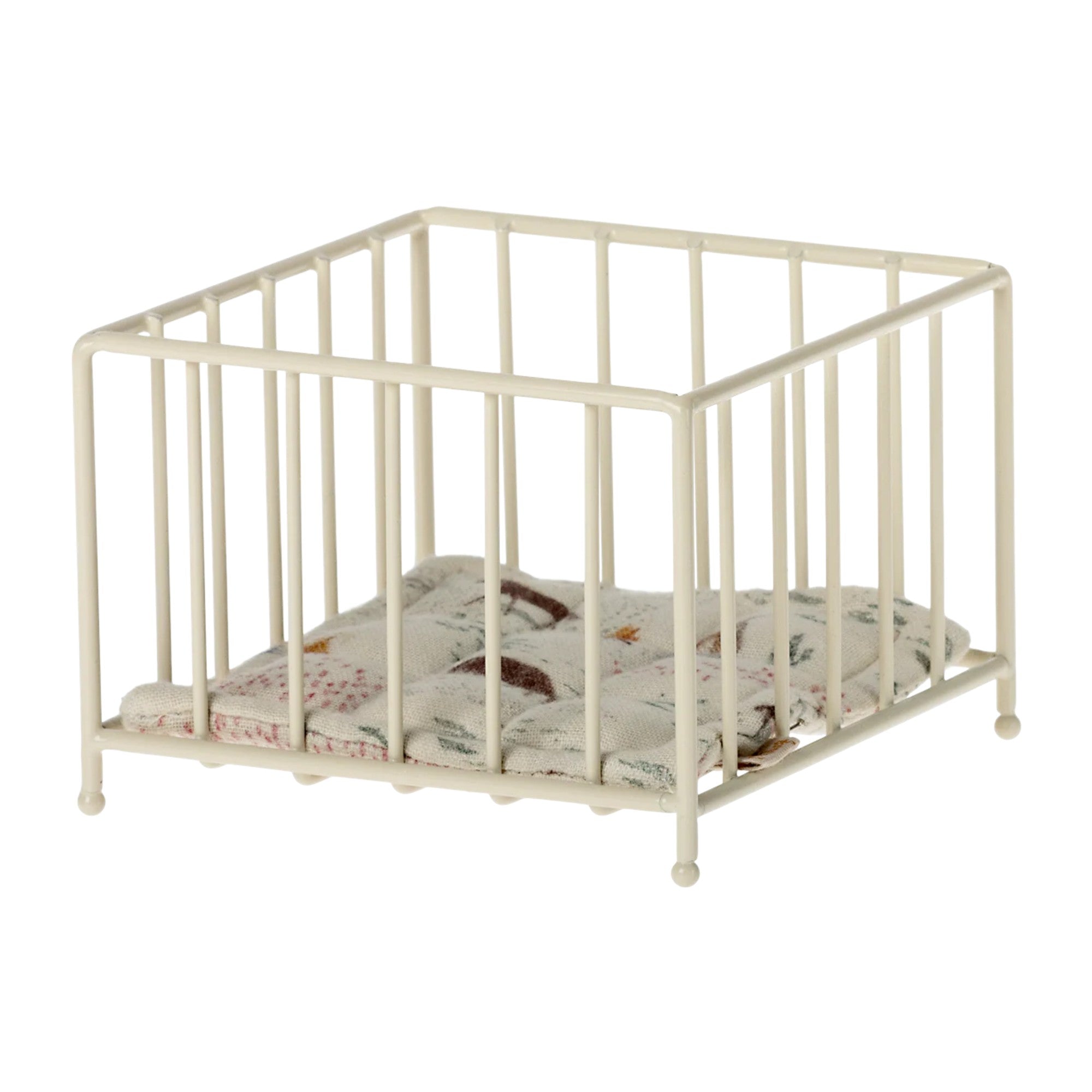 Beige metal crib with a patterned mattress on a white background