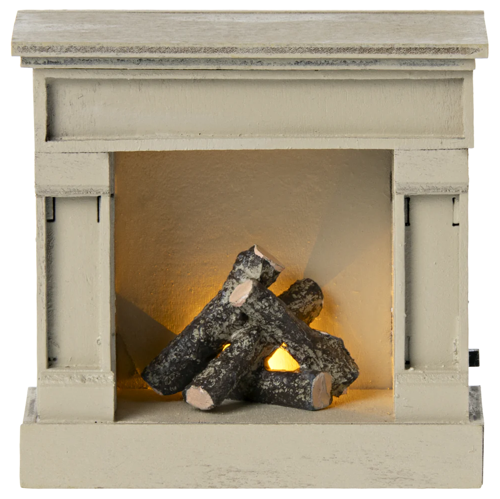 A miniature wooden fireplace with off white color and faux logs inside.