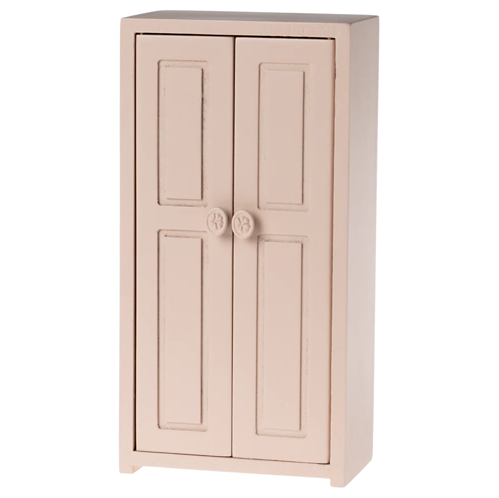 A small toy closet in a light rose color with two doors and golden hangers inside.