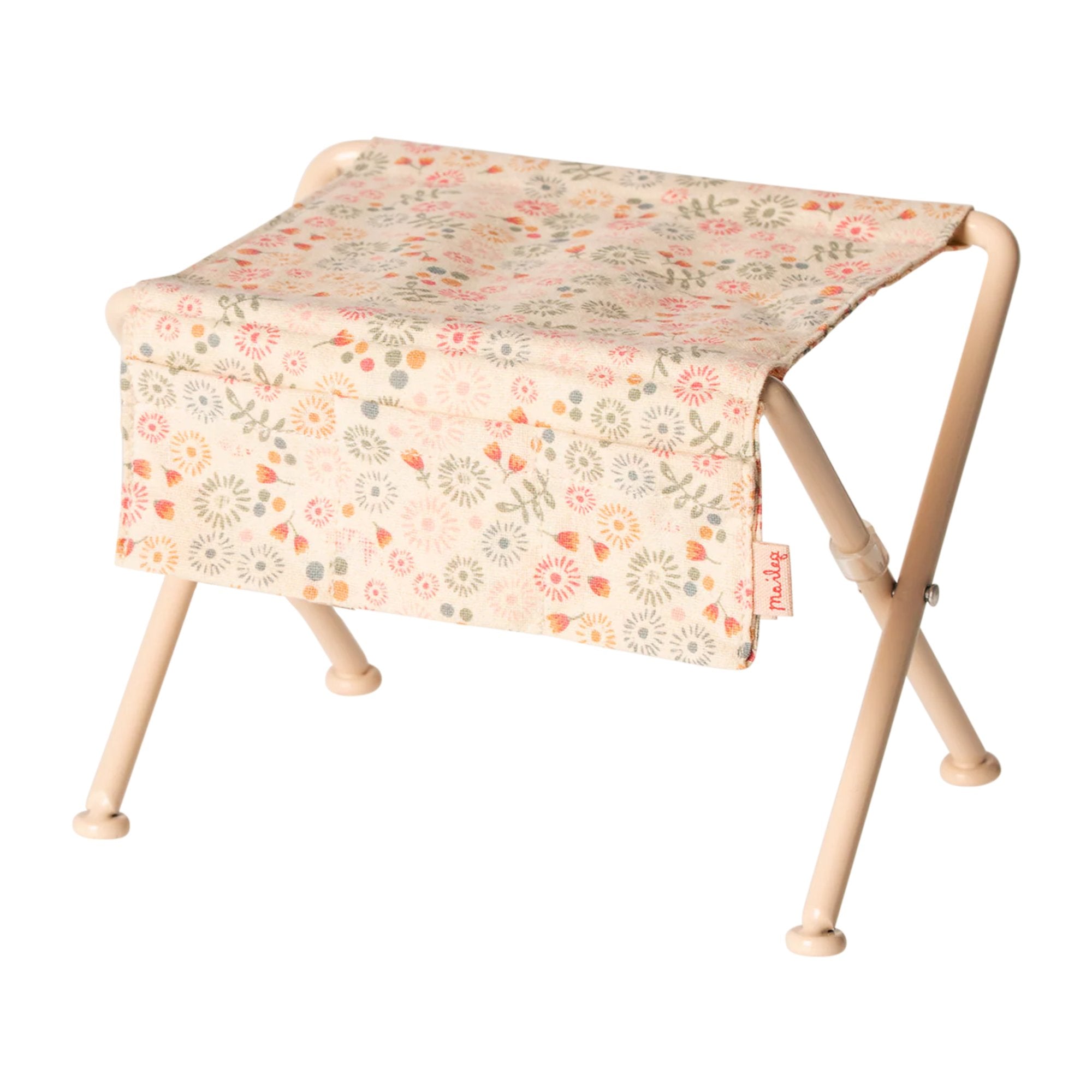 Small folding table with floral patterned cloth on a white background