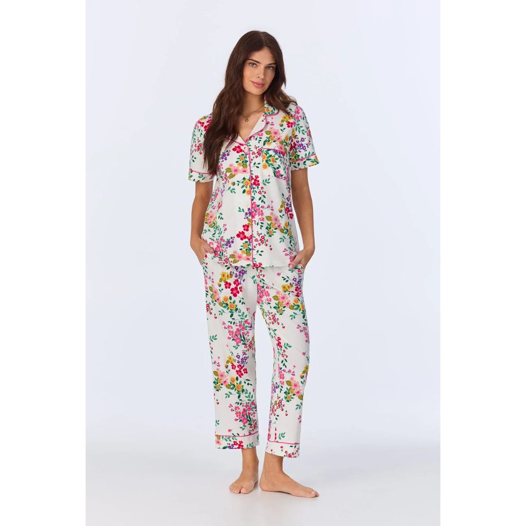 Woman wearing a floral pajama set on a white background