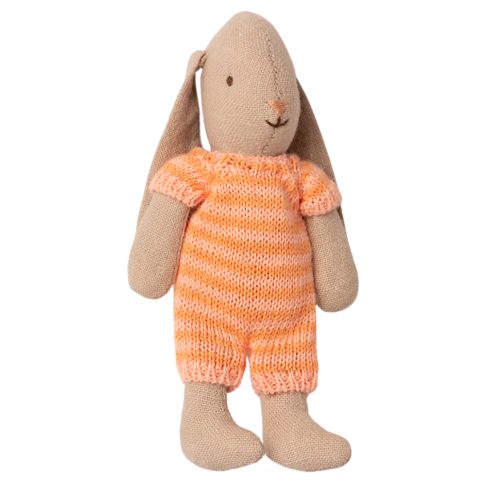 Knitted toy rabbit wearing an orange striped outfit on a white background
