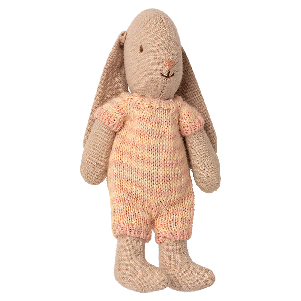 Stuffed bunny toy wearing a pink knitted outfit on a white background