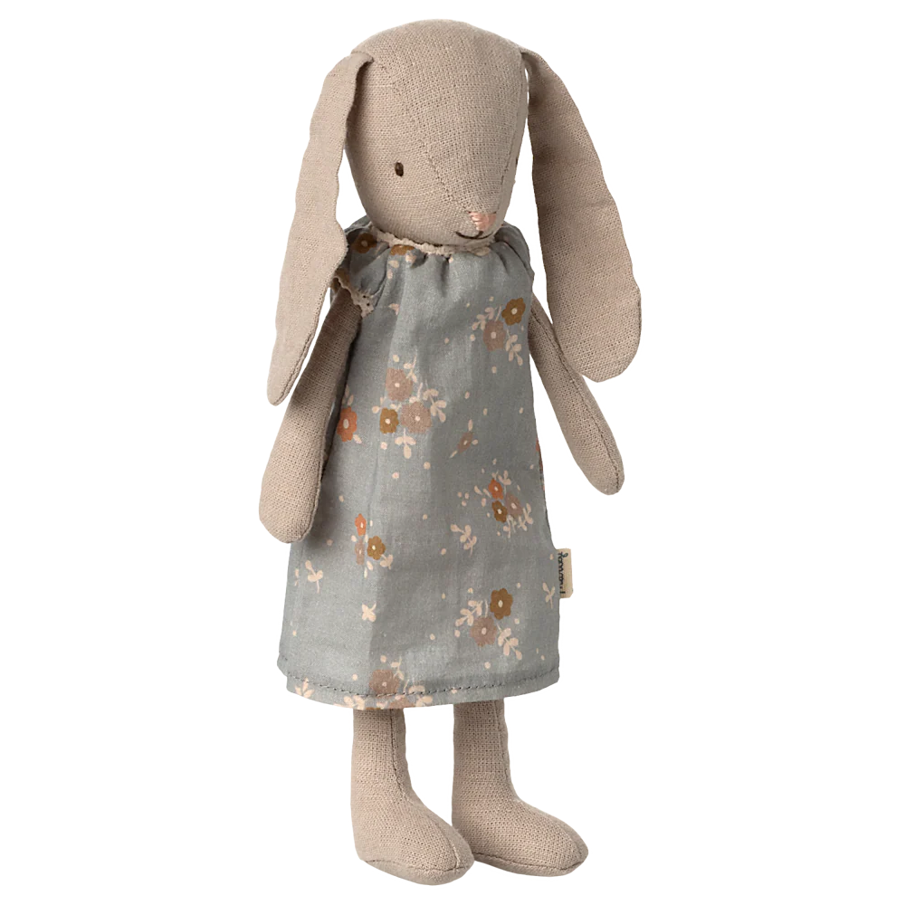Stuffed bunny toy with a floral dress on a white background