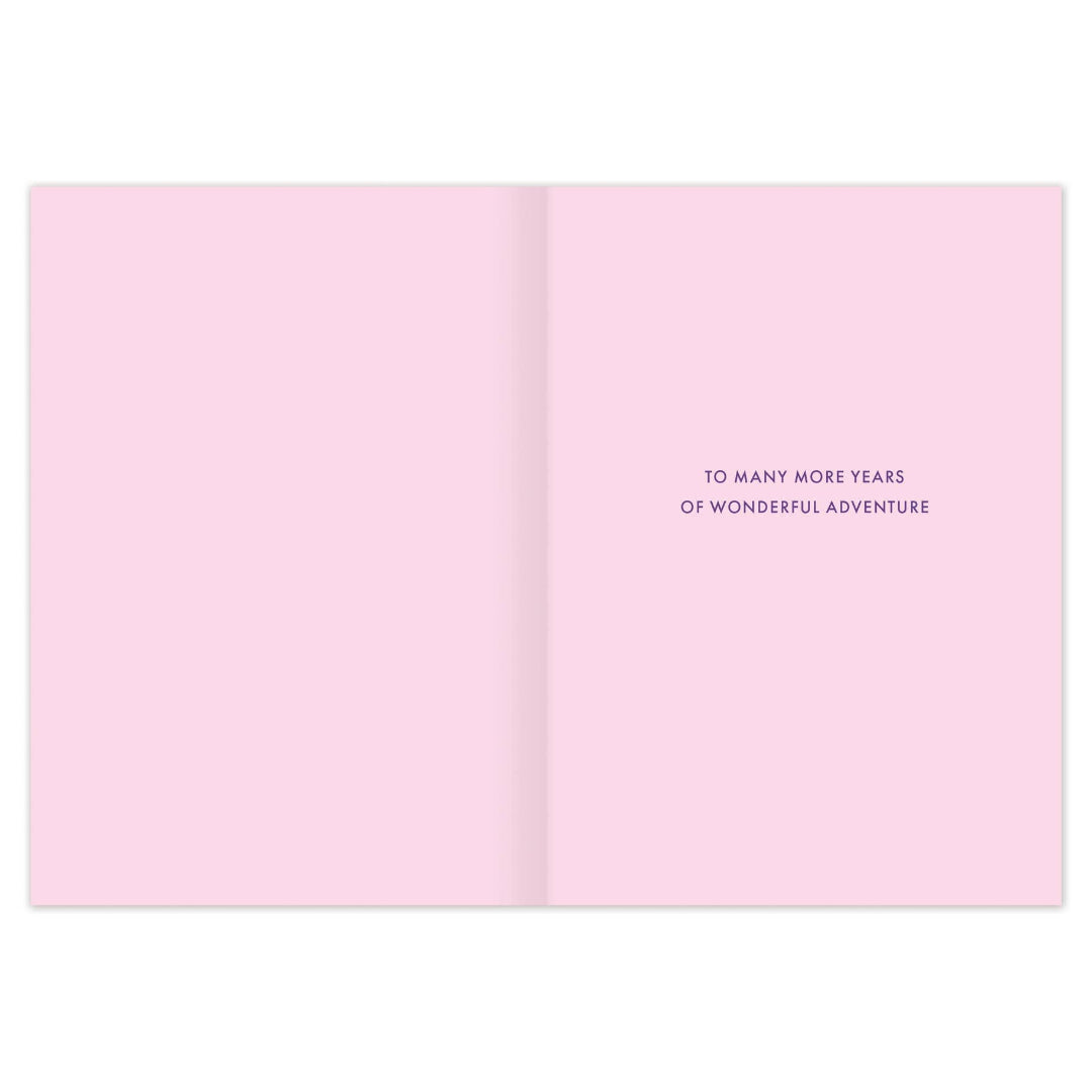 Open pink card with text 'To many more years of wonderful adventure' on a white background