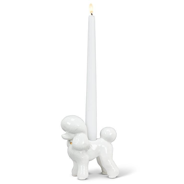 White ceramic dog-shaped candle holder with a single white candle on a white background