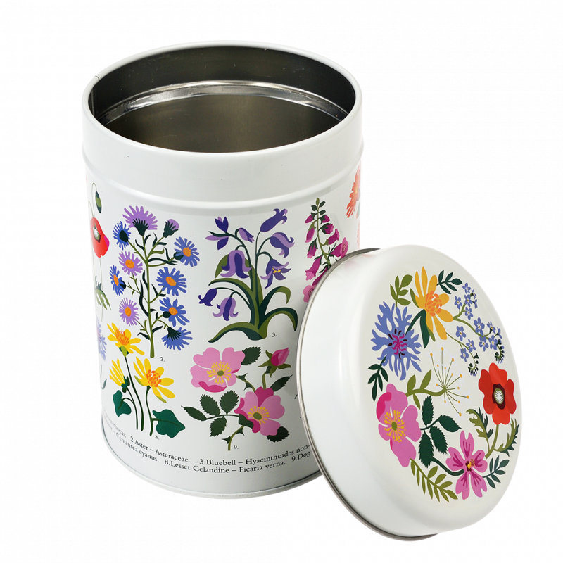 White tin canister with floral design on a white background