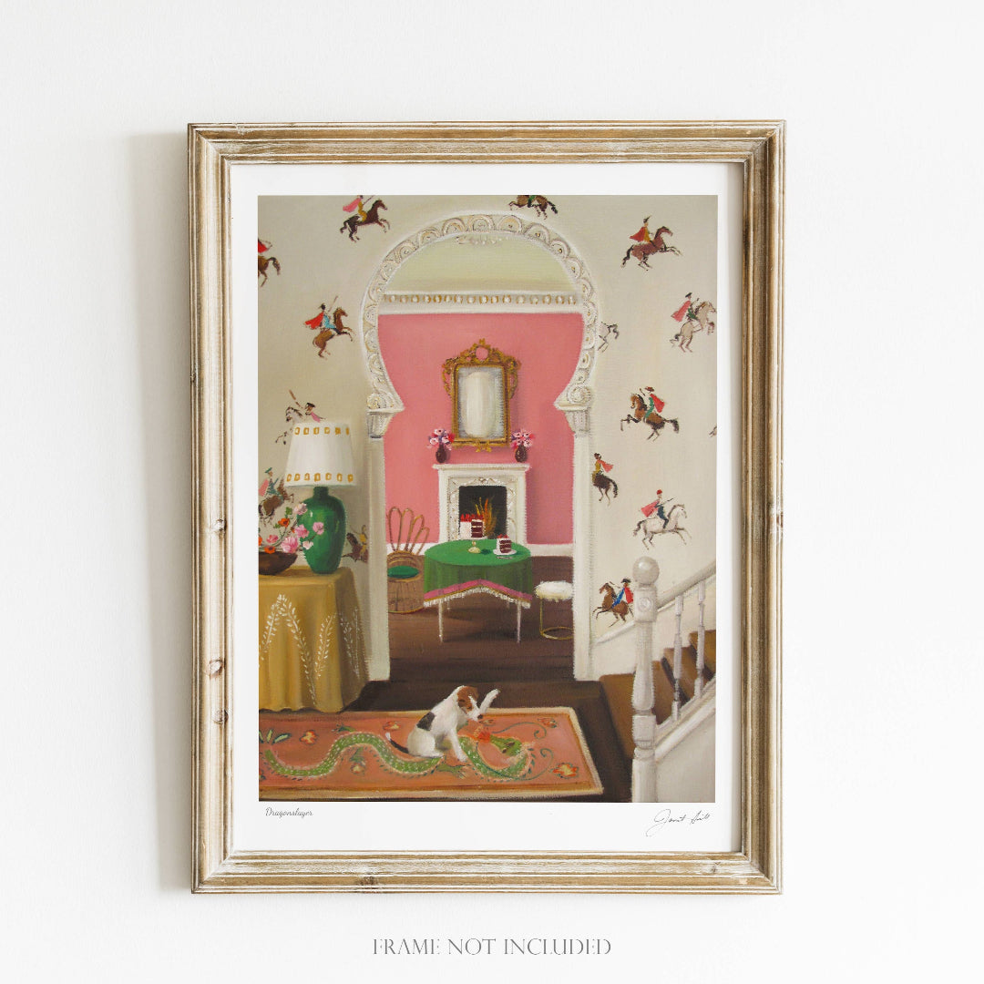 A framed art print featuring a vintage-style room with a pink wall, green fireplace, and decorative dragon motifs, including a depiction of a dog with a dragon tail.