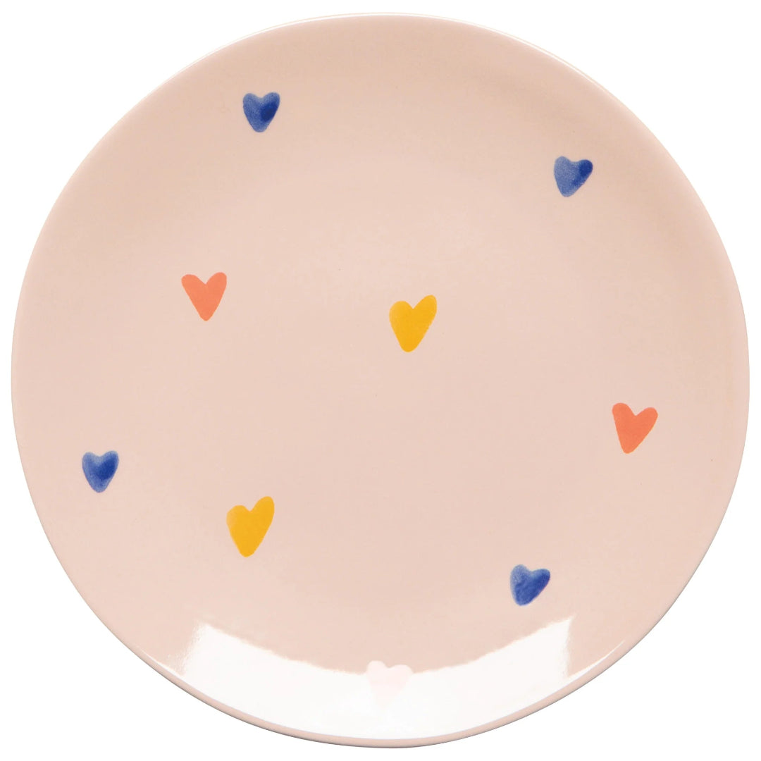 Round ceramic plate with colorful heart patterns on a beige background