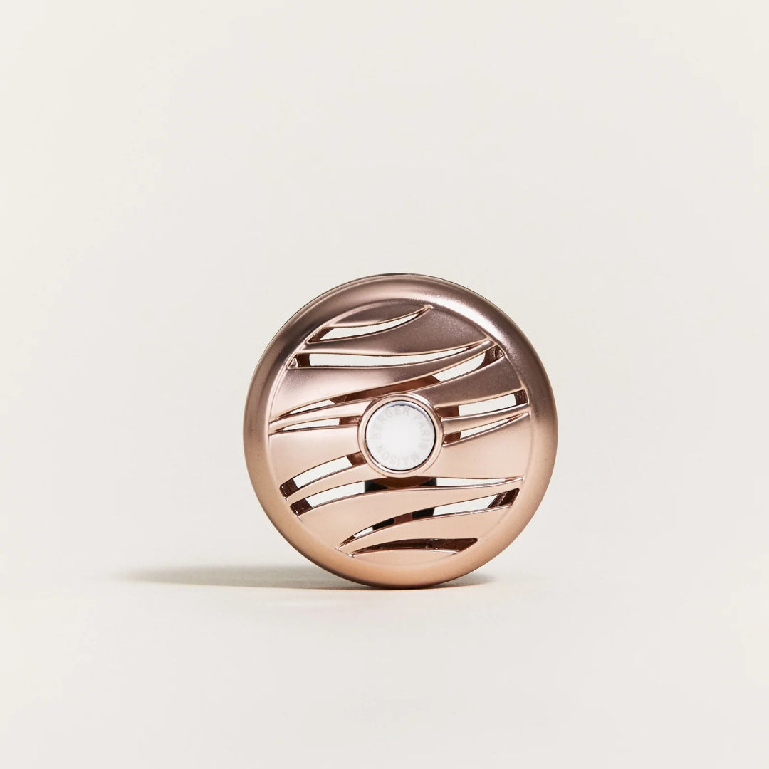 Rose gold car diffuser on a light beige background