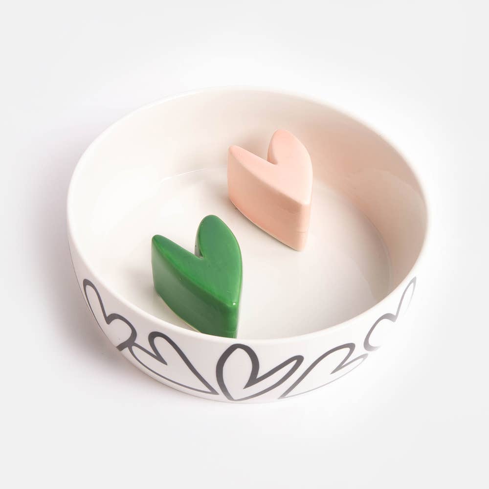 White dish with pink and green hearts on a white bowl on a white background