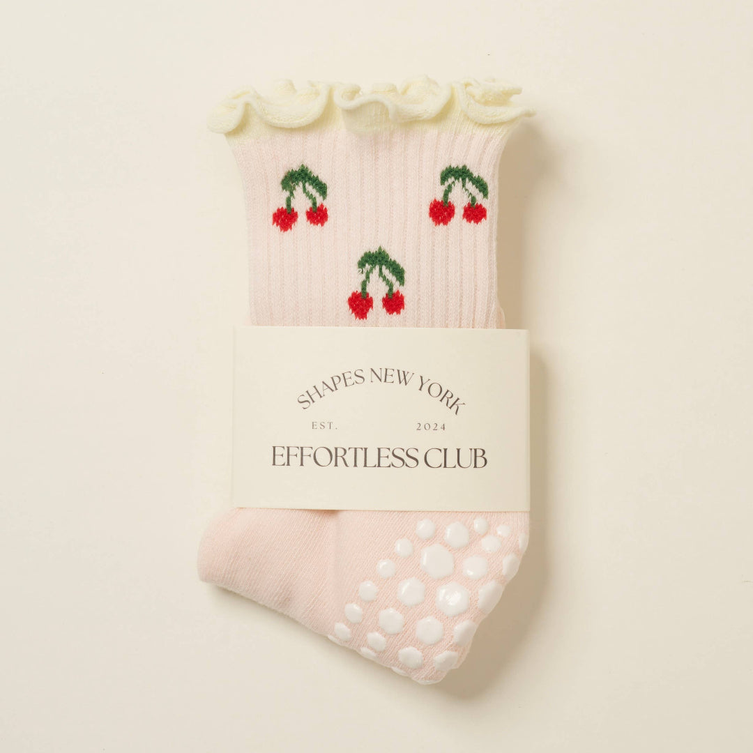 Pack of socks with cherry design and 'Effortless Club' branding on a light background