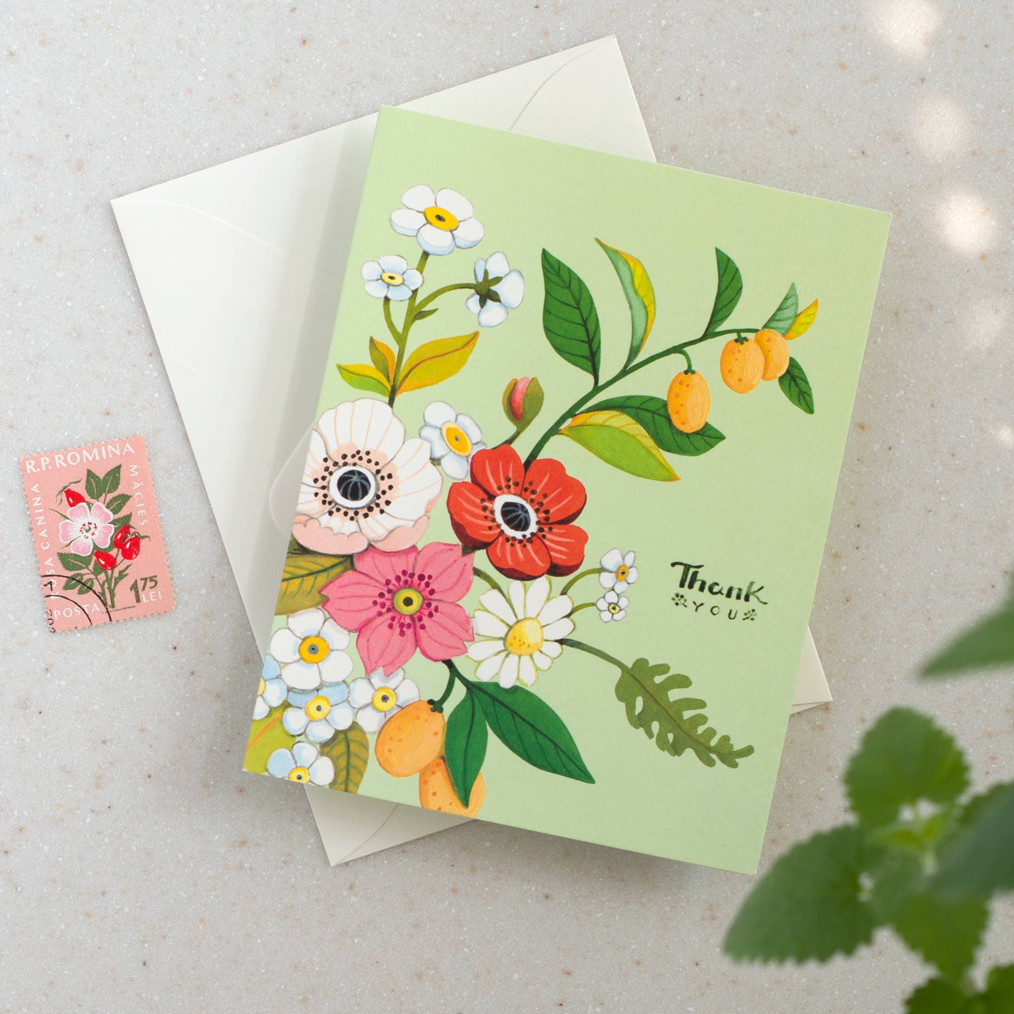 Floral card with envelope and stamp on a light background