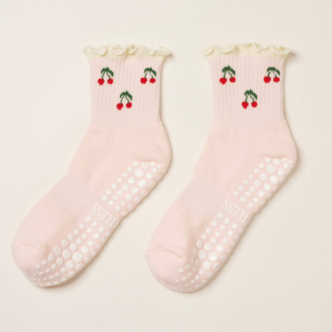Pair of pink socks with cherry design on a light background