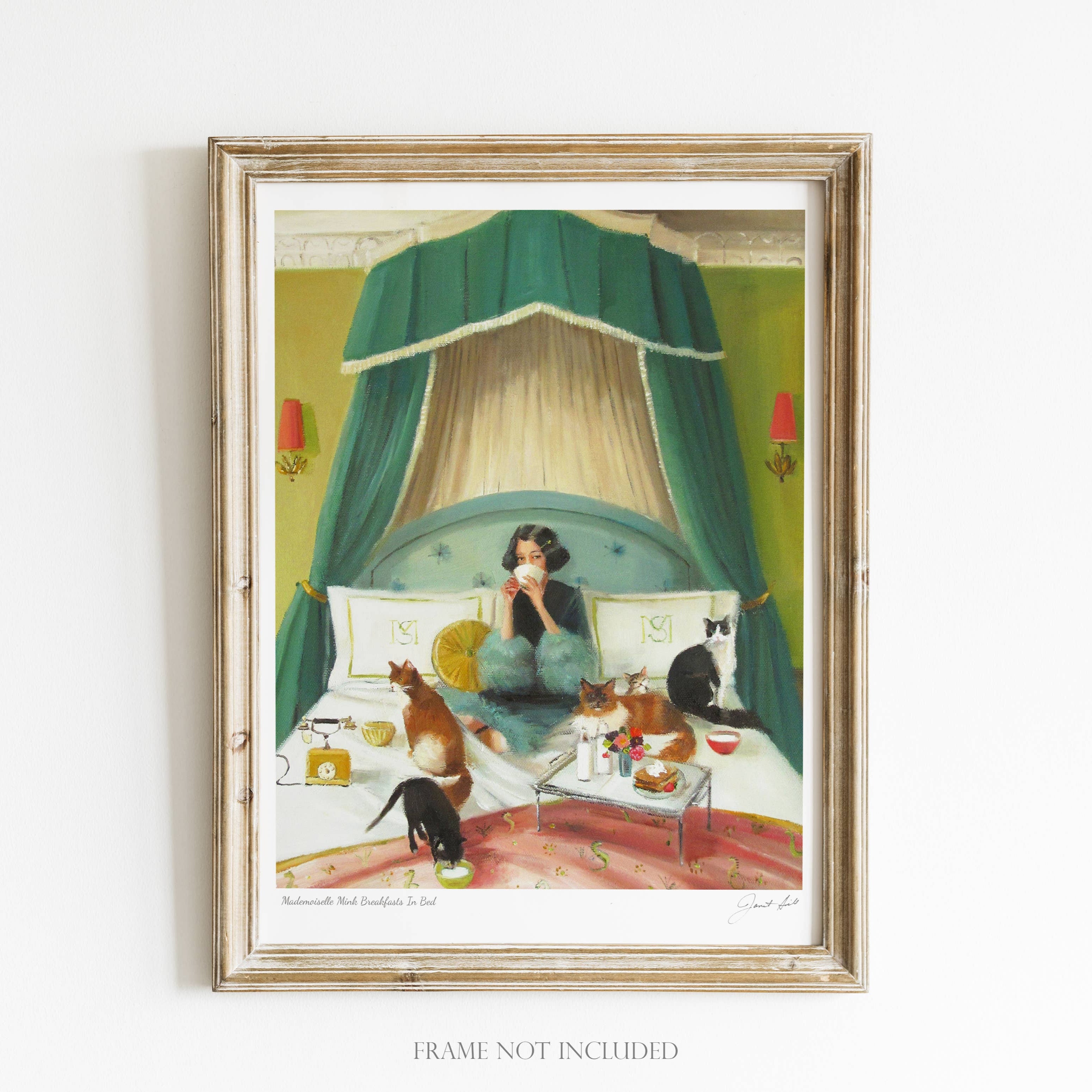 A framed art print featuring a whimsical scene with a woman in bed with cats, a dog, and a breakfast tray.