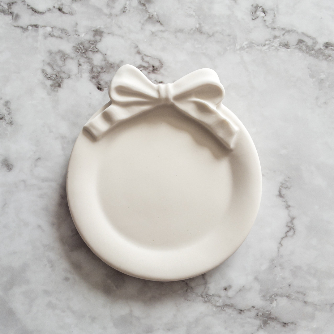 White dish with a bow on a marble surface