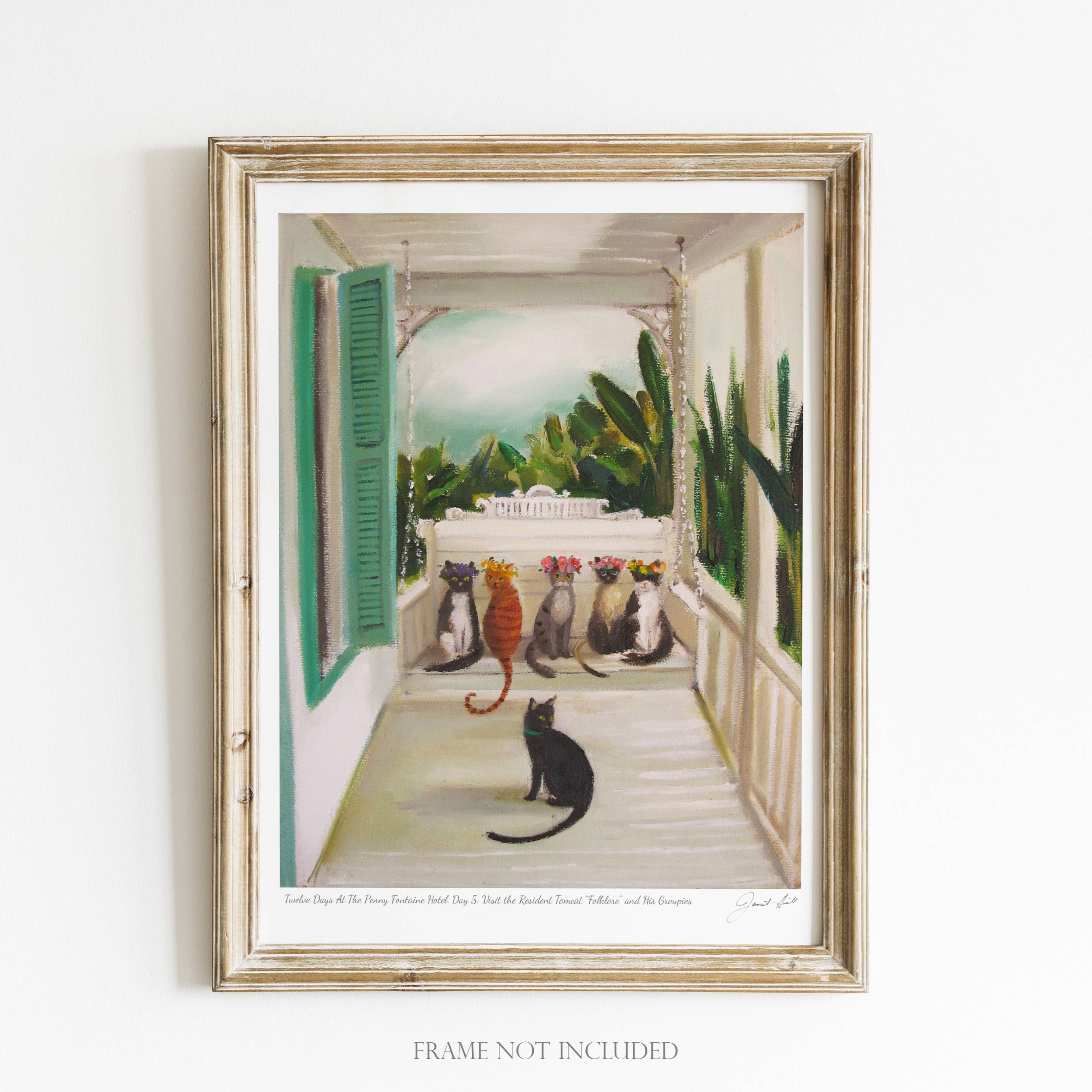 A framed art print featuring a colorful illustration of cats on a porch, with a green plant and a white rack in the background.
