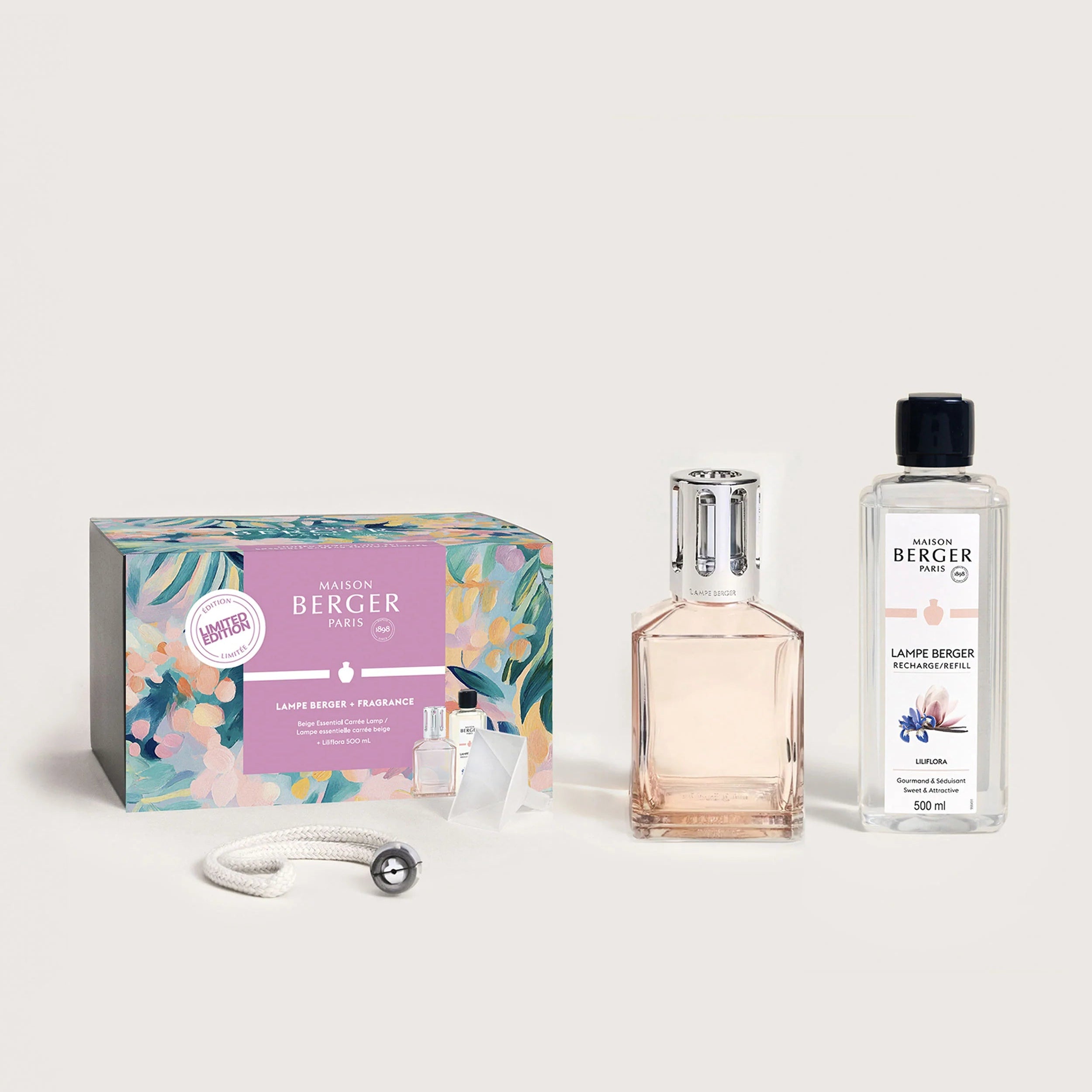 A gift set of a Blush Beige Carrère fragrance lamp with a floral patterned box, a clear glass bottle refill, and a white decorative element.
