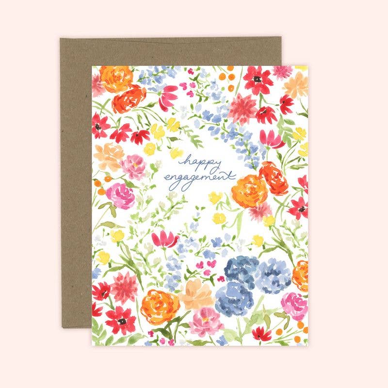A colorful floral engagement card with the text 'happy engagement' on the front, accompanied by a kraft envelope.