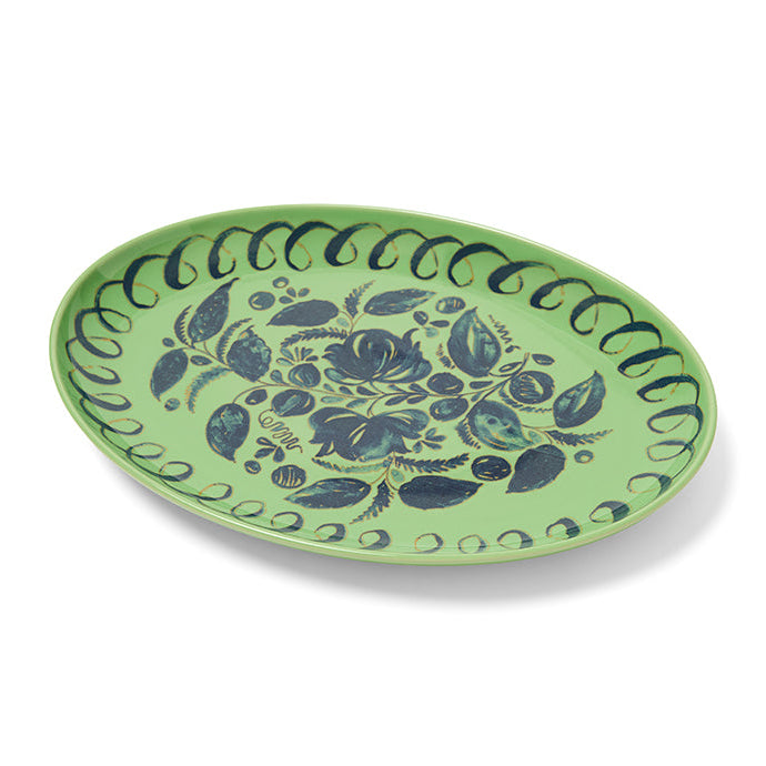 Green ceramic plate with blue floral pattern on a white background