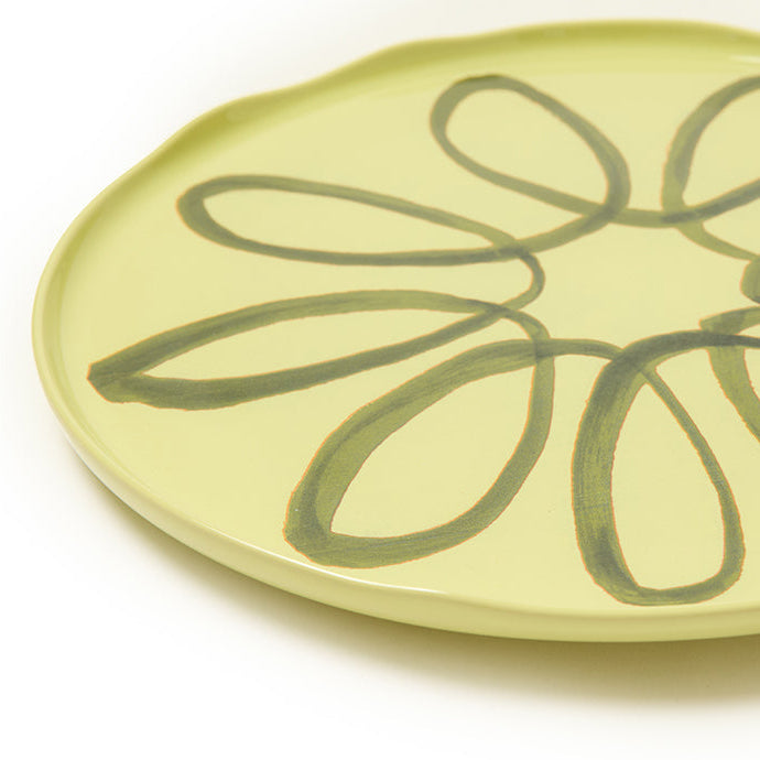 Green ceramic plate with floral design on a white background