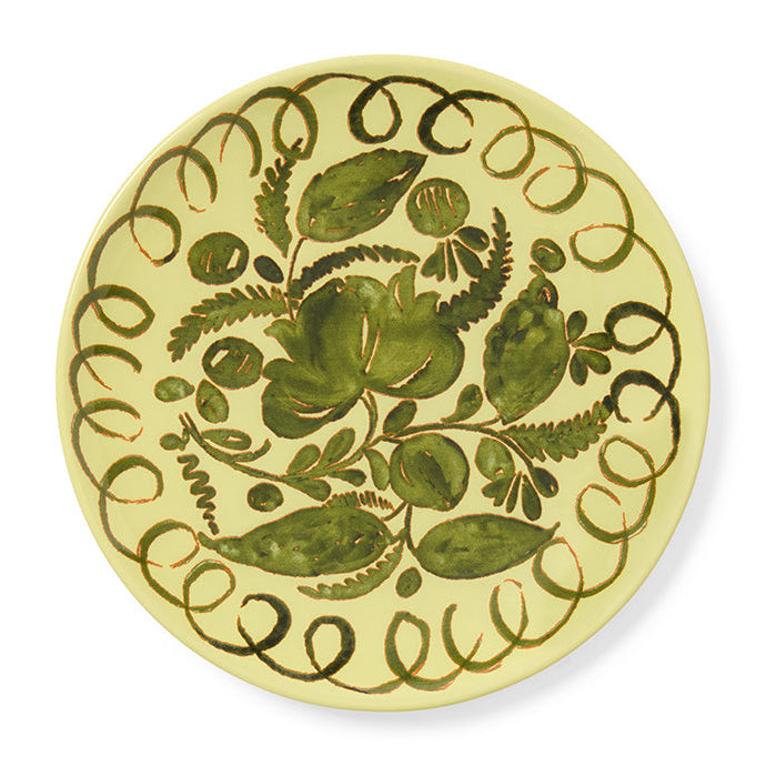Decorative plate with green floral design on a yellow background