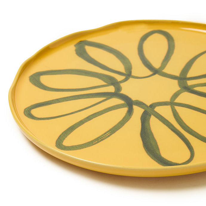 Yellow plate with green floral design on a white background