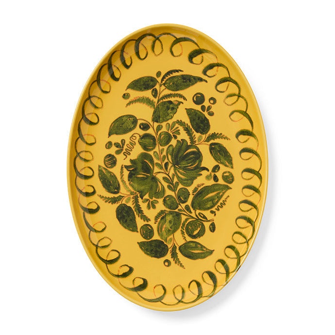 Decorative yellow plate with green floral patterns on a white background