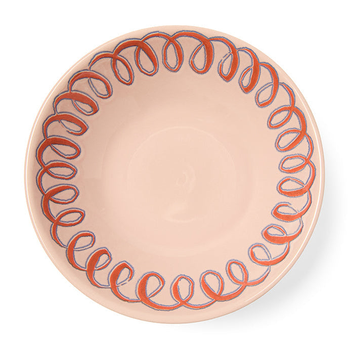 Pink ceramic plate with decorative pattern on a white background