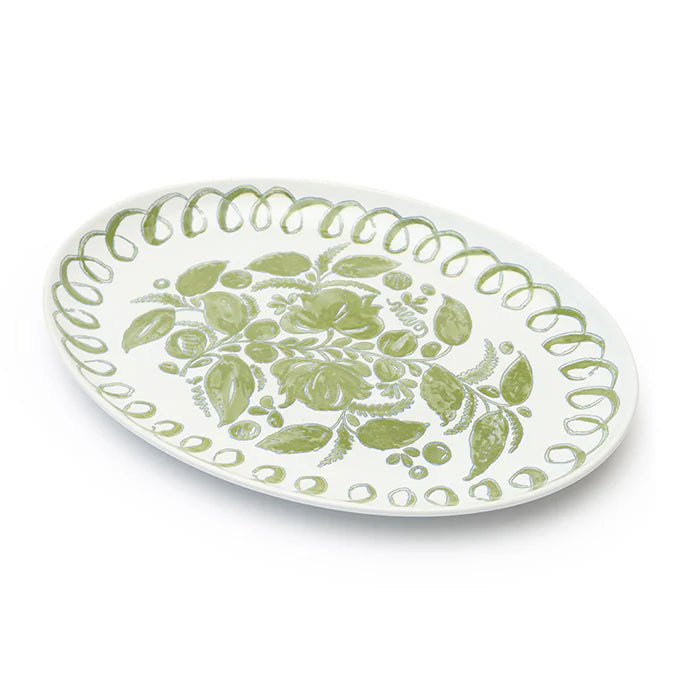 An oval white ceramic serving platter decorated with a light green floral pattern in the center and a scalloped green border, shown on a clean white background.