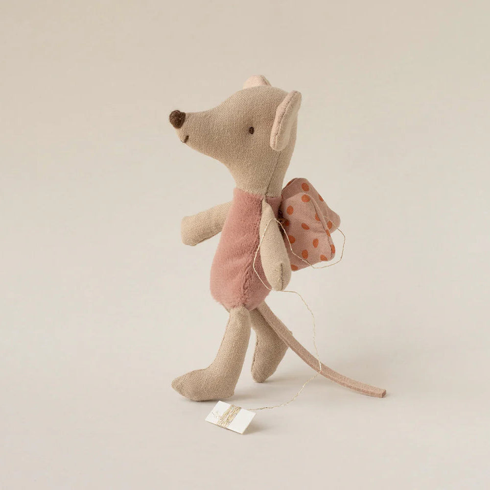 Stuffed mouse toy with a pink bow on a beige background