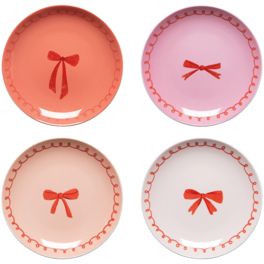 Four decorative plates with red bows on a white background