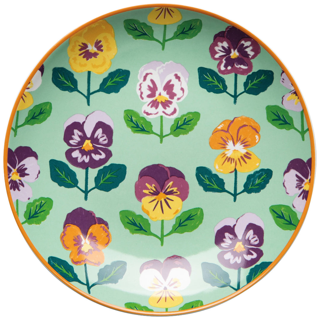 Decorative plate with colorful pansy flower pattern on a green background