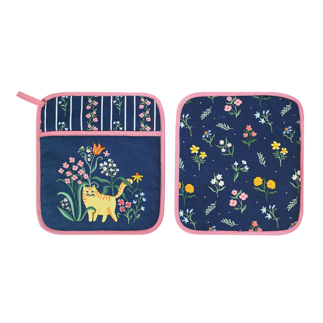 Two navy blue pot holders with floral and cat designs on a white background