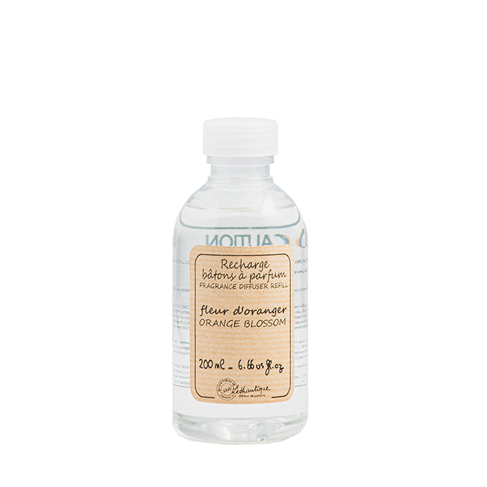 A clear bottle of Authentique Orange Blossom diffuser refill with a white label.