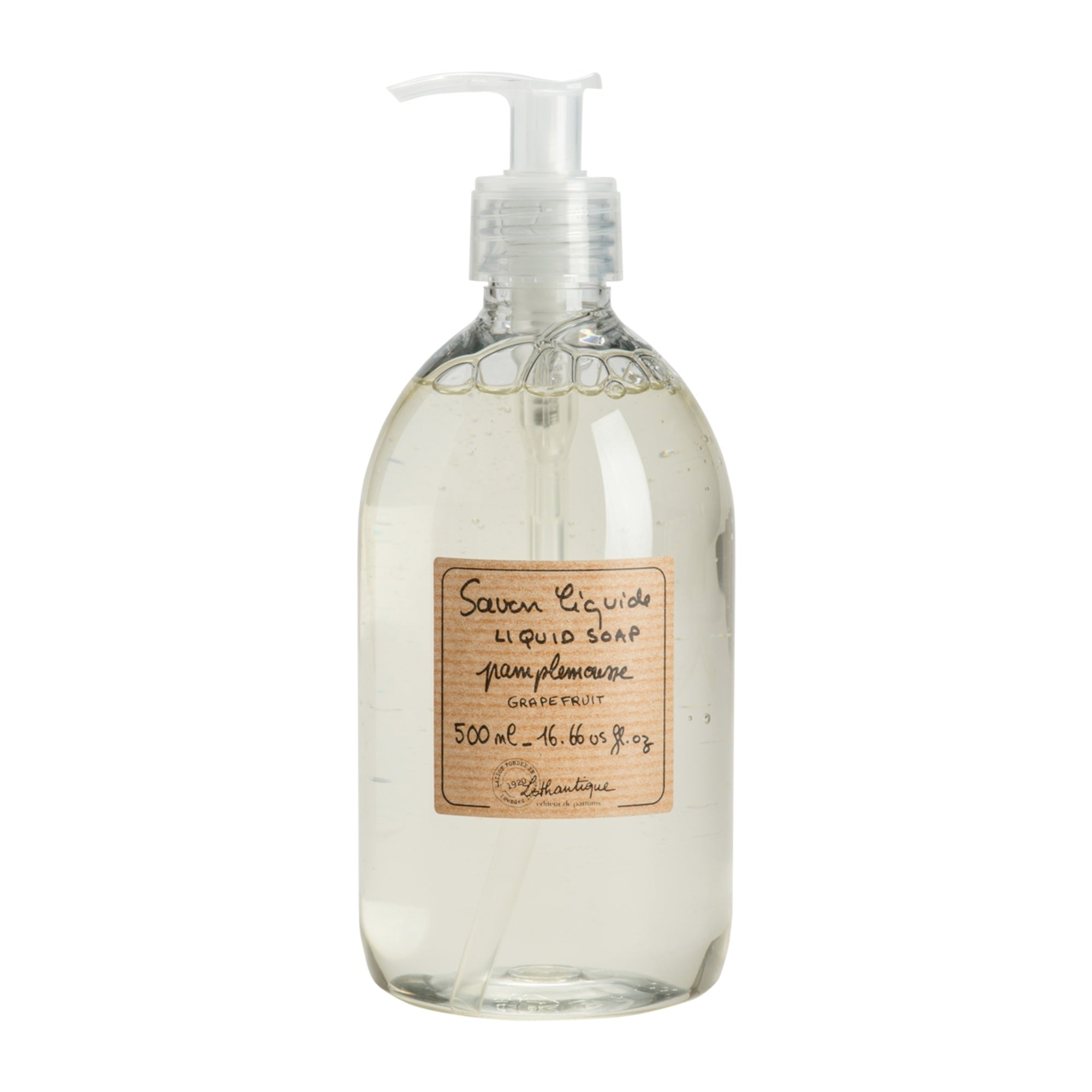 Clear glass bottle of liquid soap with a pump and wooden label on a white background