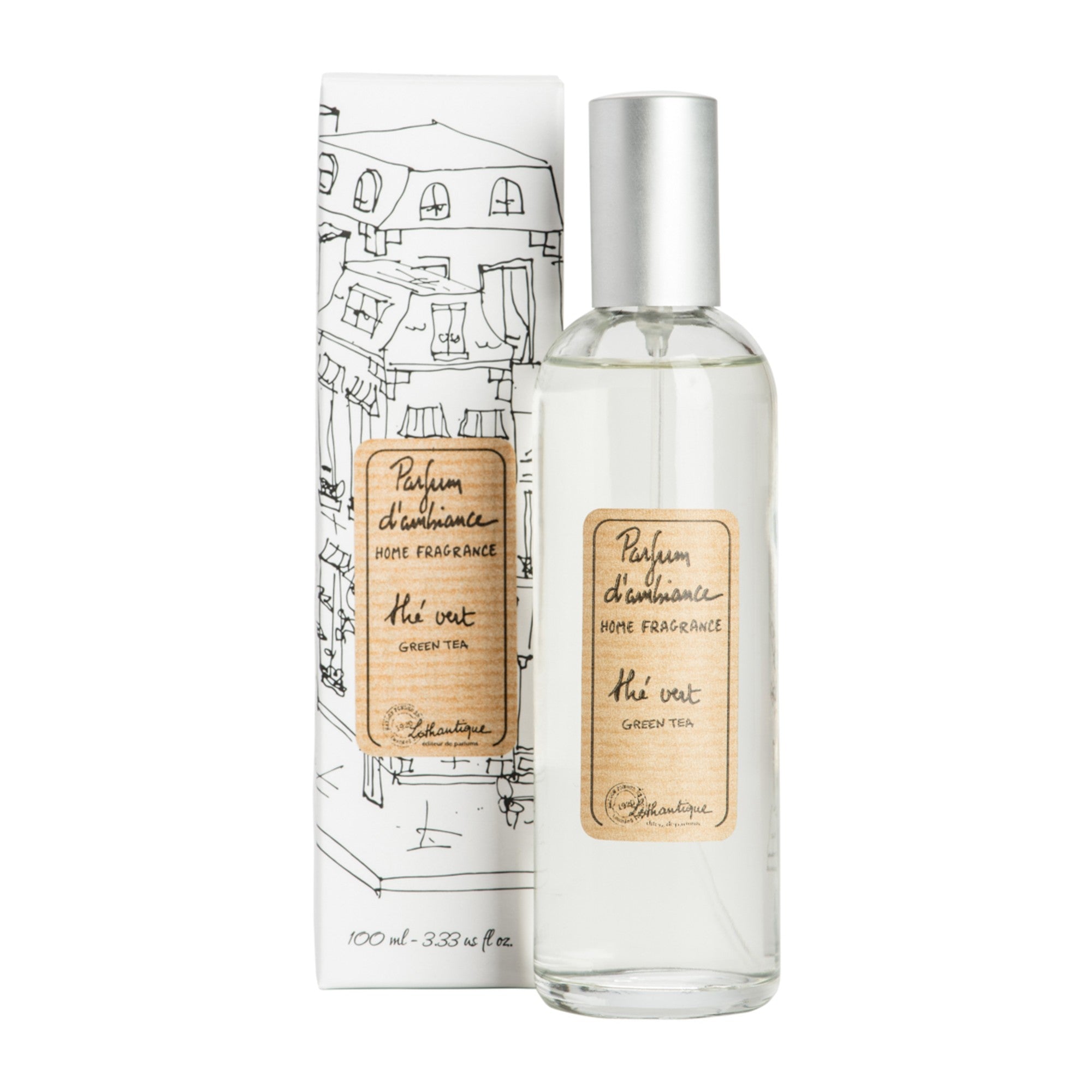 A clear glass room spray bottle with a label next to its packaging featuring a drawing of a house.