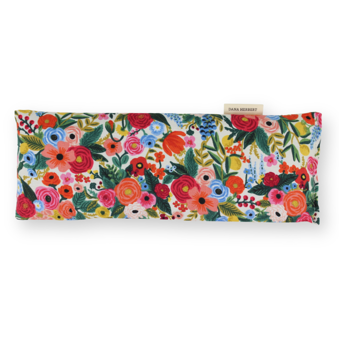 An eye pillow with a vibrant multicolor floral print