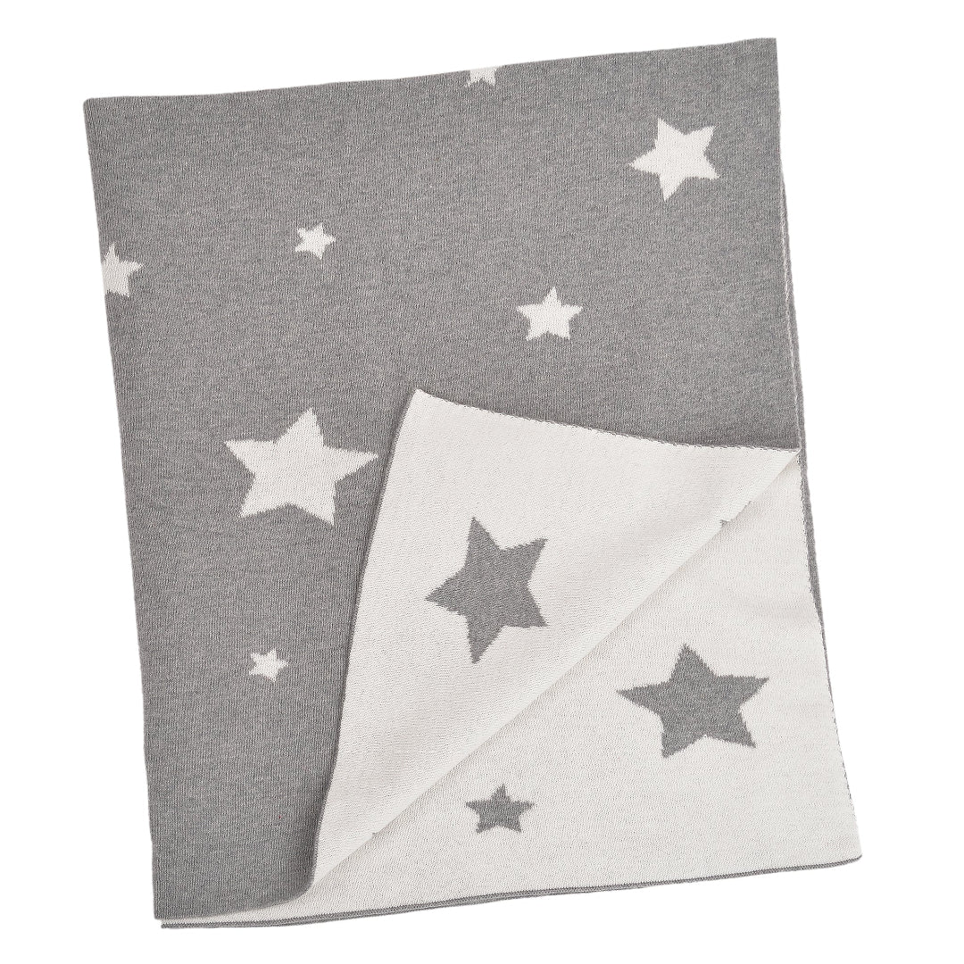 A grey baby blanket with white stars and a solid white corner, laid out flat.