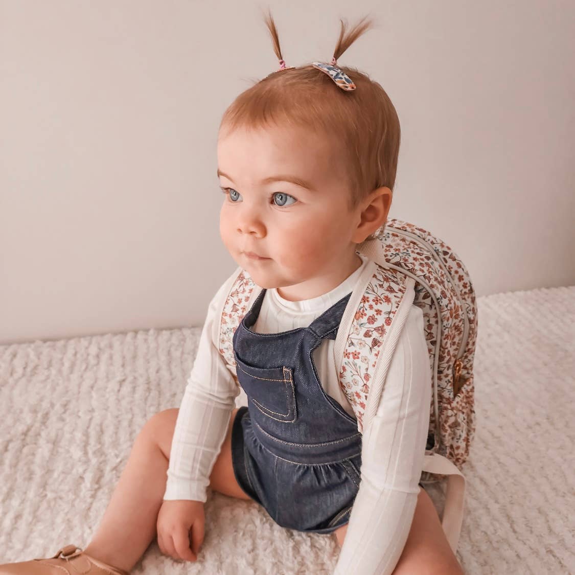 Toddler sitting in Liberty London Backpack