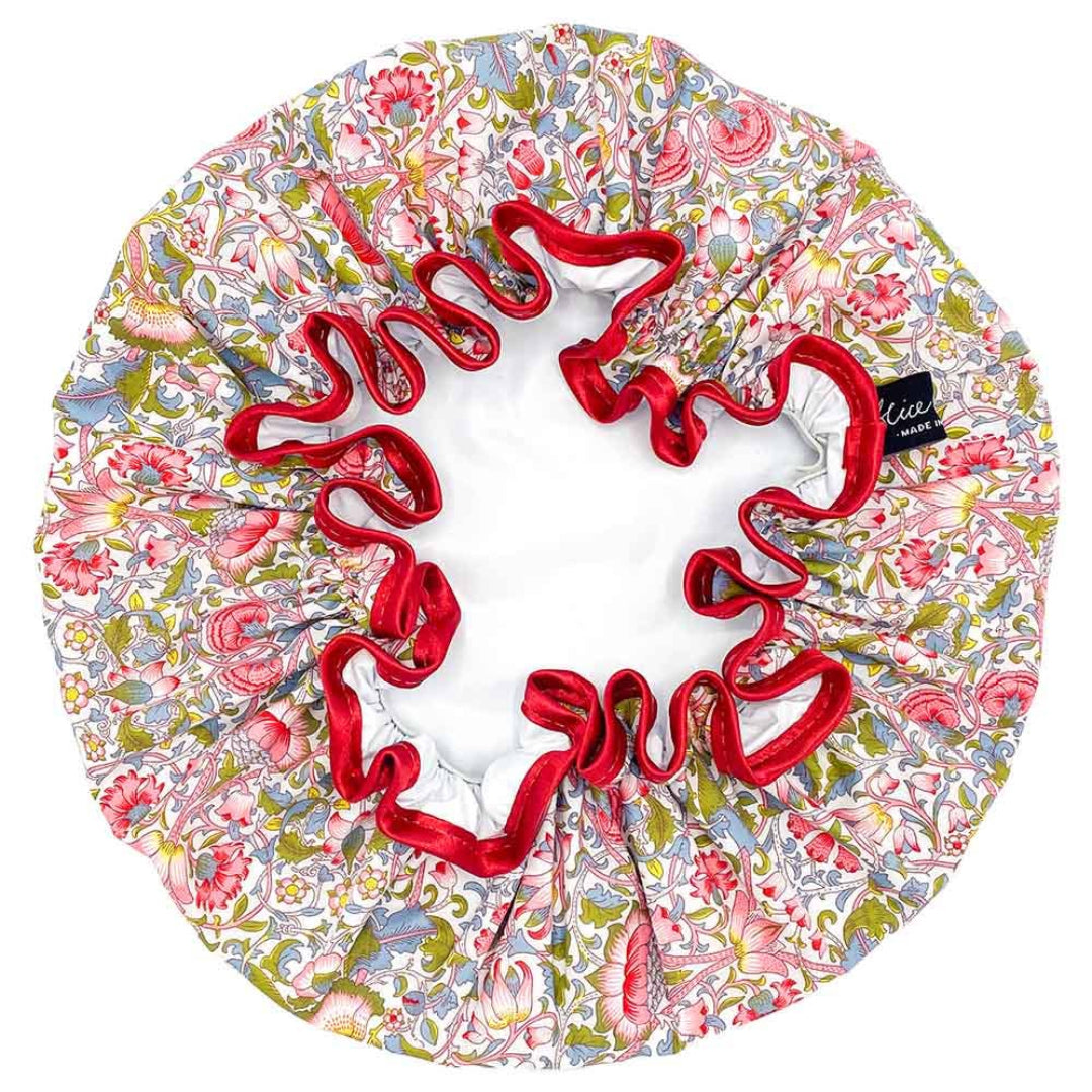 A floral patterned shower cap with red satin ribbon edging.