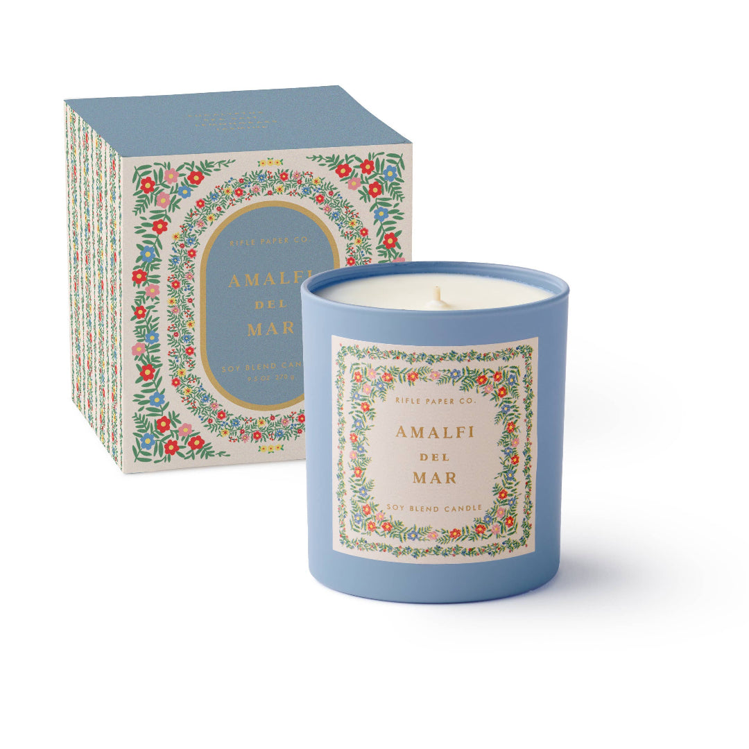 Blue candle with decorative label and matching box on a white background