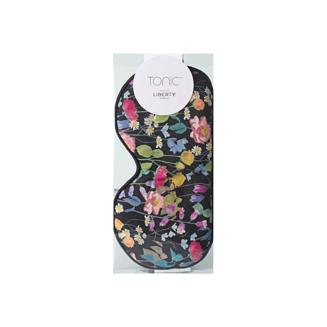A floral printed eye mask with multicolored blooms, packaged in a clear-front box with 'Tonic Liberty' branding.
