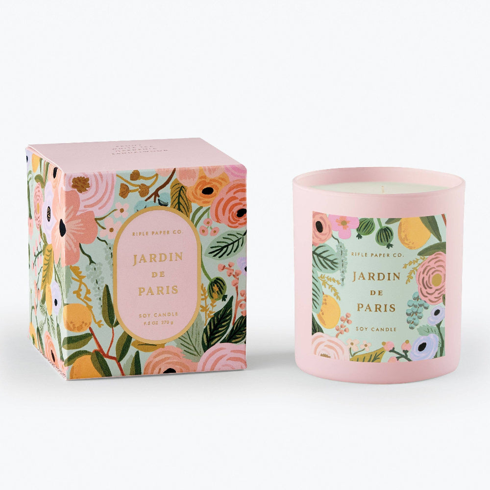 A floral-patterned candle and its decorative packaging with gold foil accents.