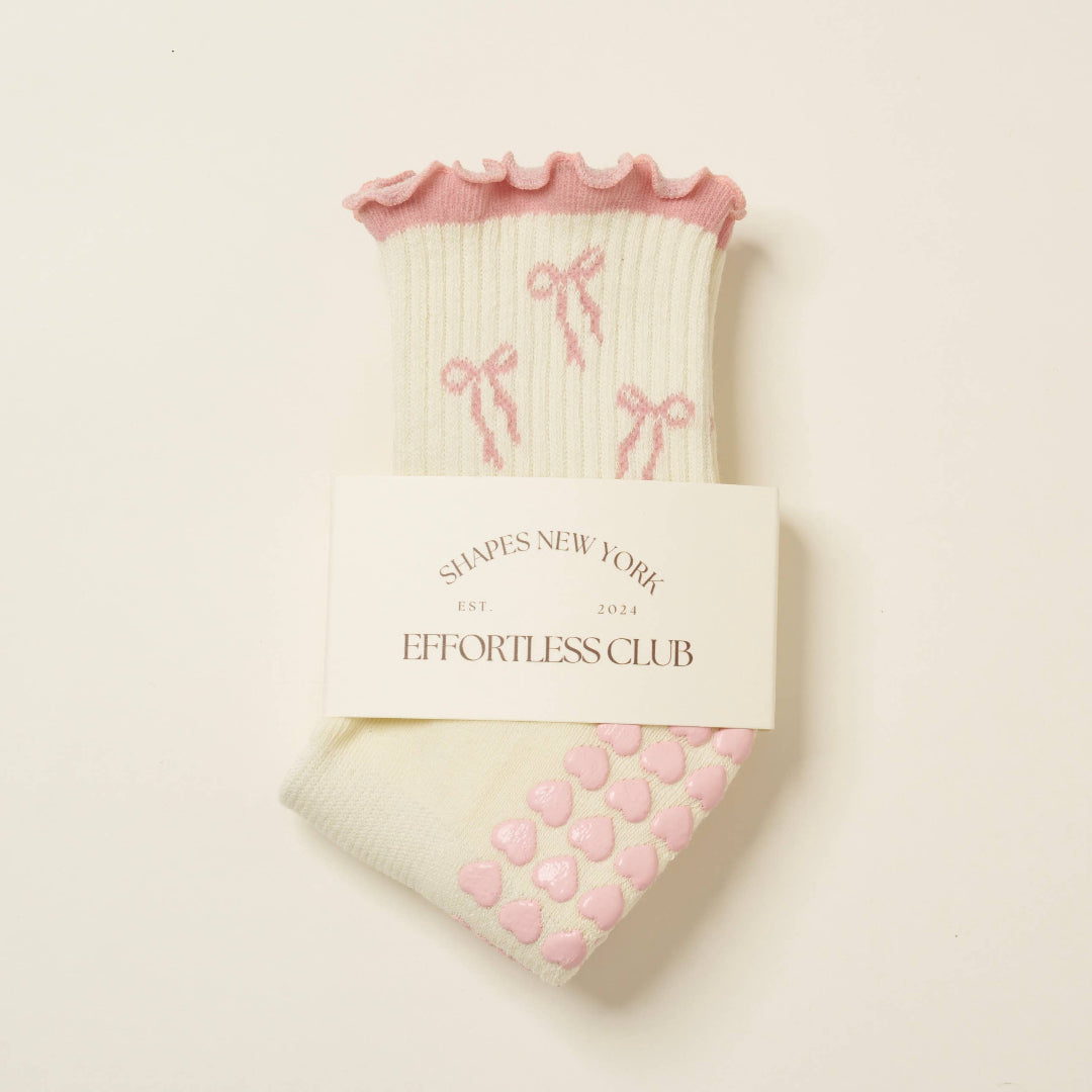 Pair of socks with decorative bows on a light background