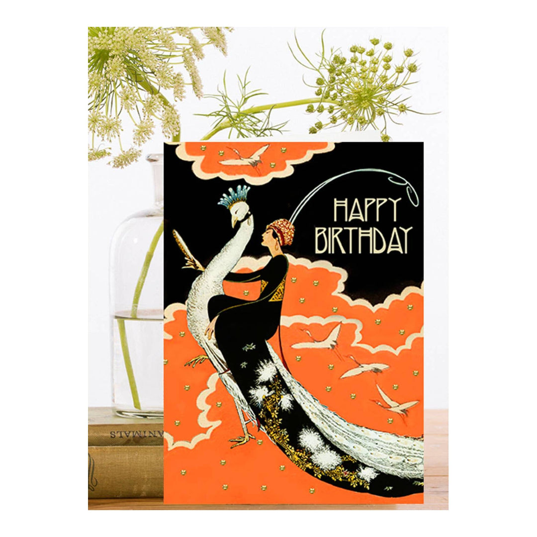 Carte d'anniversaire avec femme scintillante à la main sur un paon