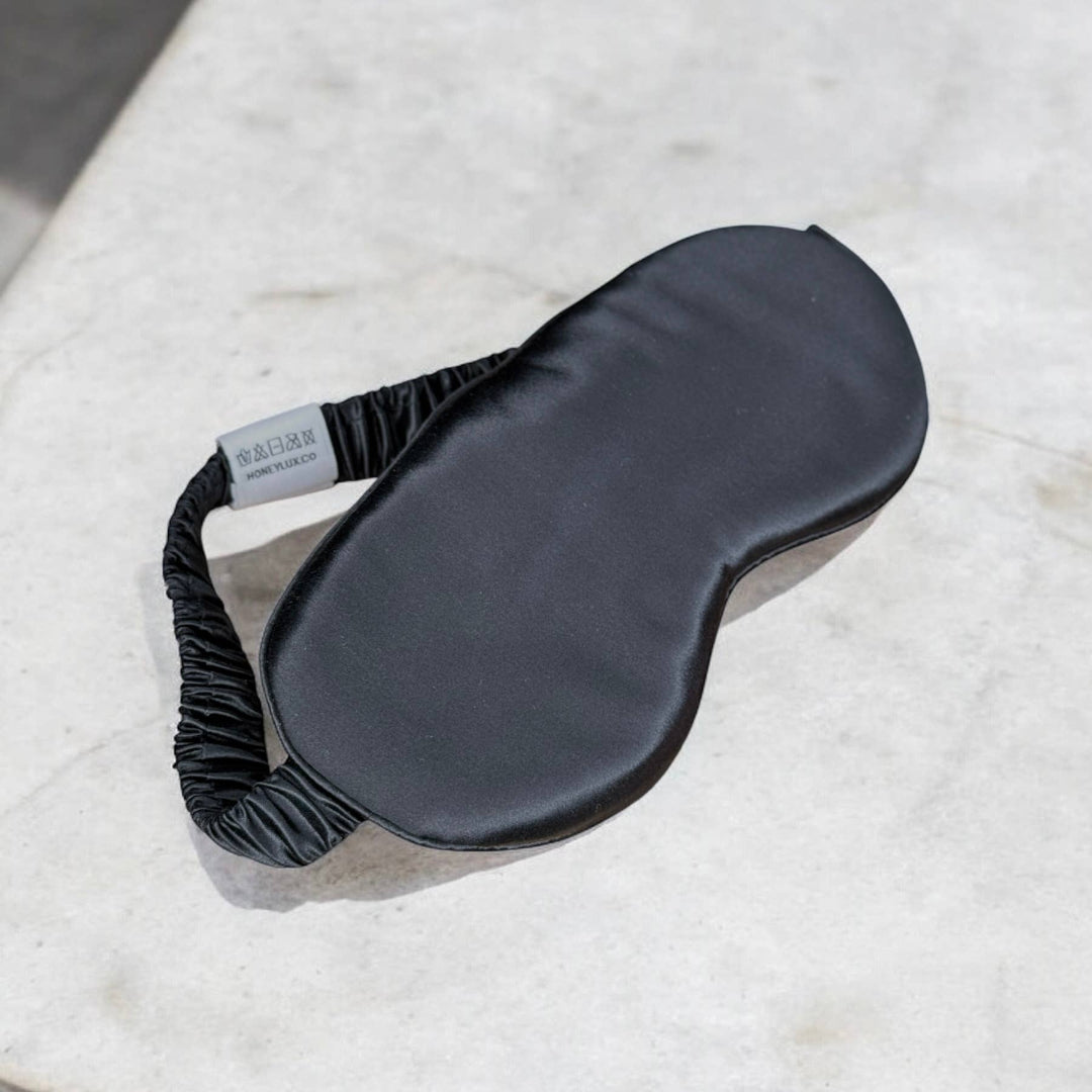 Black sleep mask on a textured white surface