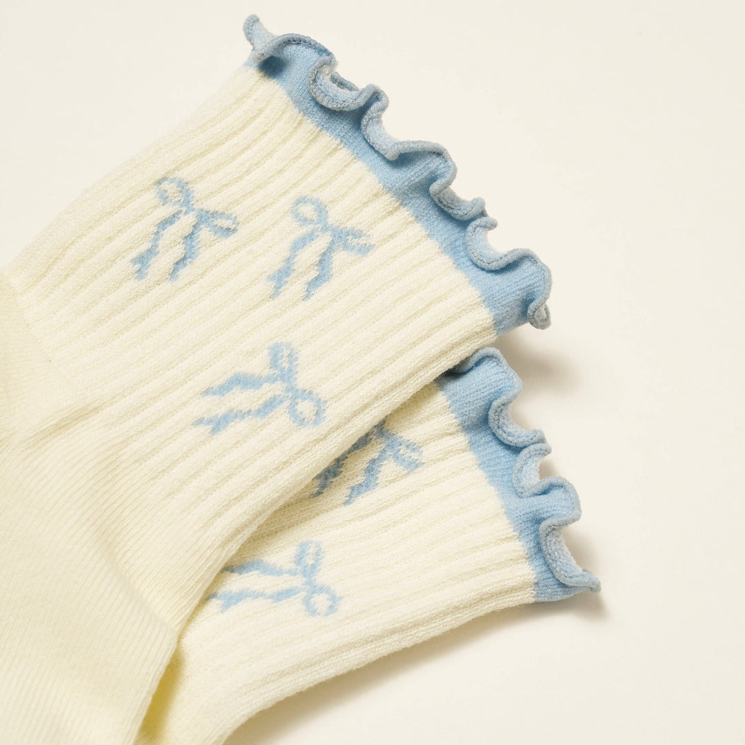 Cream-colored sock with blue trim and embroidered designs on a light background